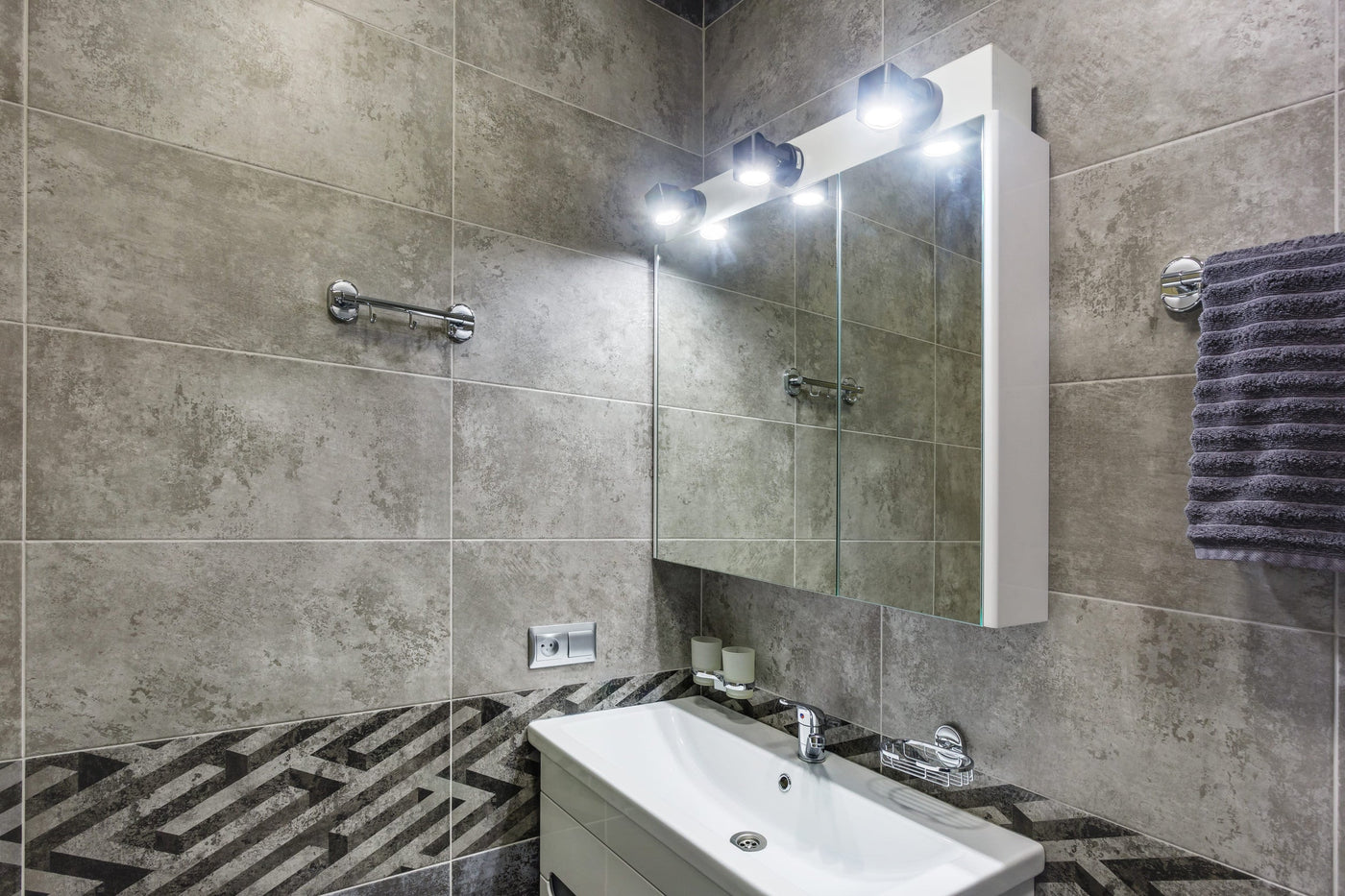 Modern bathroom vanity with a lit mirror and vanity light bar