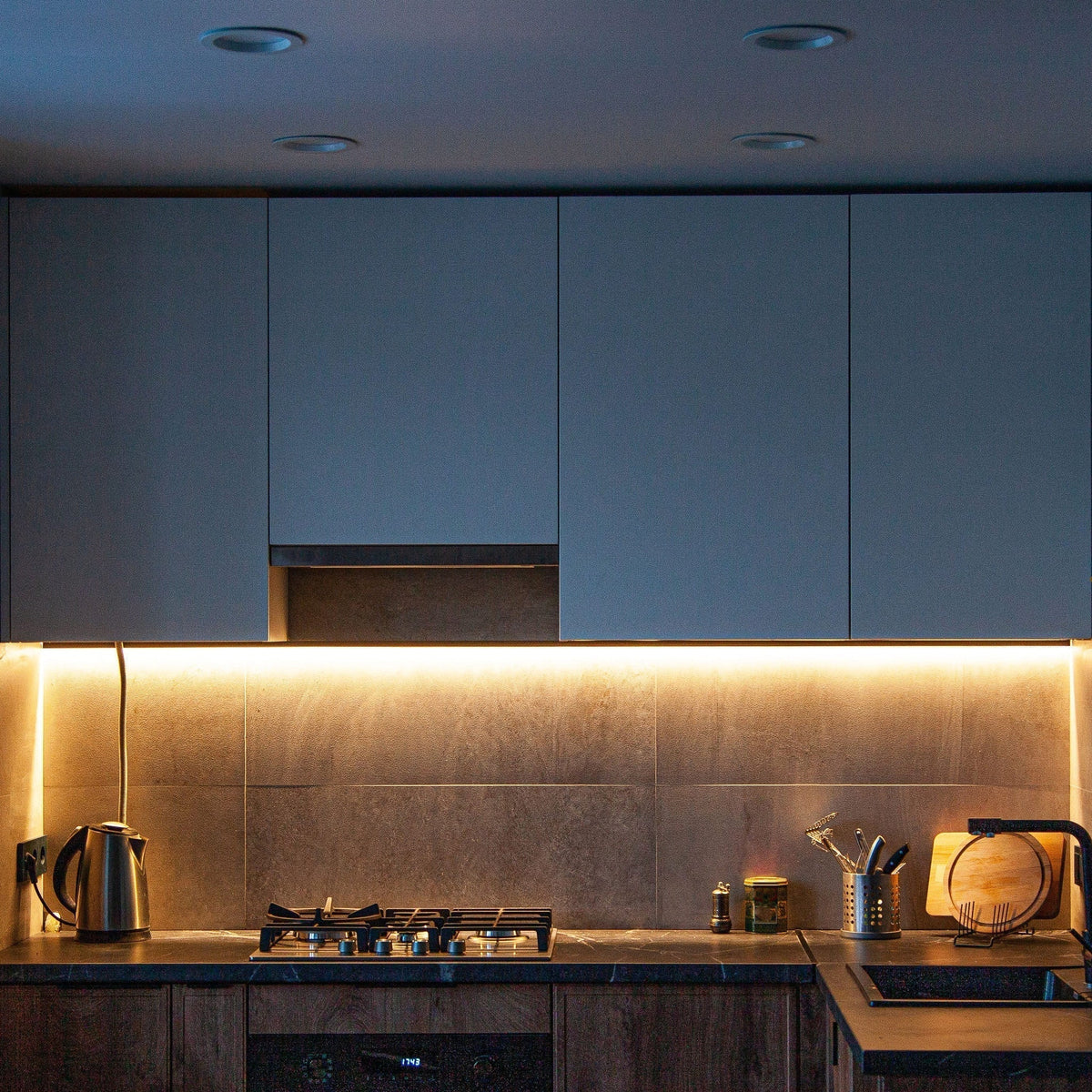 Kitchen counter lit by warm under cabinet LED strip lights