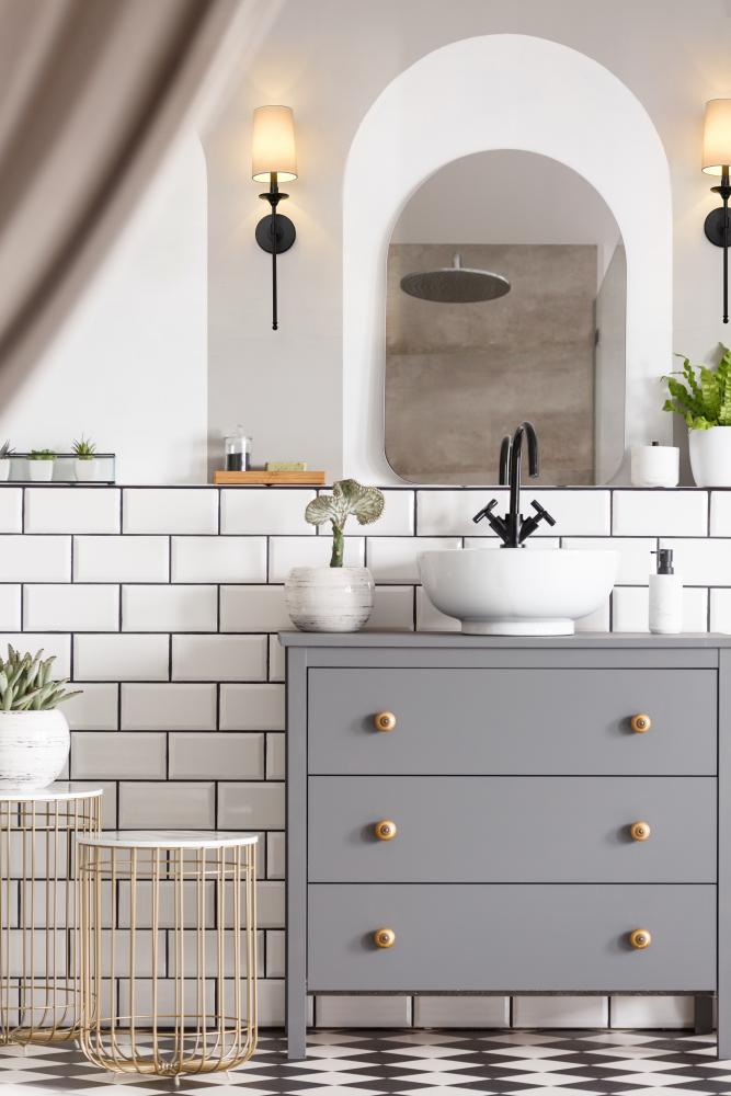 Bathroom vanity with an arched mirror and two wall sconces